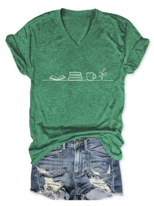 Flat lay of a green V-neck T-shirt with book and coffee print and ripped denim shorts
