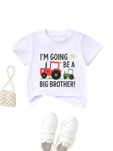 Flat lay of white Big Brother T-shirt with tractor print and toddler sneakers