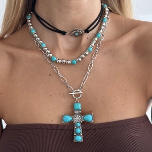 Detailed view of layered bohemian necklace set featuring turquoise cross and flower pendants