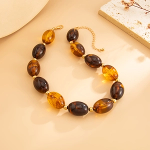 Detailed view of amber resin beaded necklace with gold metal spacers and lobster clasp
