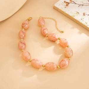 Detail of pink marble resin beads with gold accents and adjustable lobster clasp