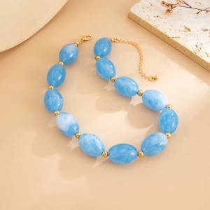 Detail of blue marble resin beads and golden lobster clasp on chic ethnic necklace
