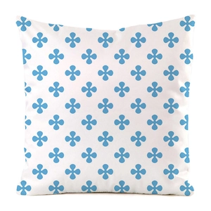 Détail du motif quatrefeuille bleu sur une housse de coussin blanche en soie synthétique