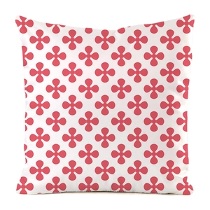 Détail de la housse de coussin blanche avec motifs géométriques floraux rouges à quatre pétales
