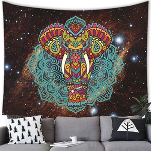 Tenture éléphant mandala avec ciel étoilé suspendue au-dessus d'un canapé gris