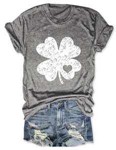 Flat lay of a grey T-shirt with a vintage clover heart print and denim shorts on white