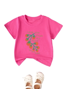 Detail of pink cotton t-shirt for kids with tomato print and white lace shoes