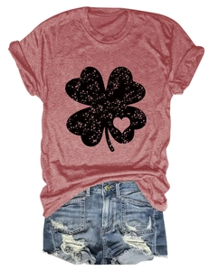 Detail of distressed clover print with heart cutout on a red-brown crew neck T-shirt