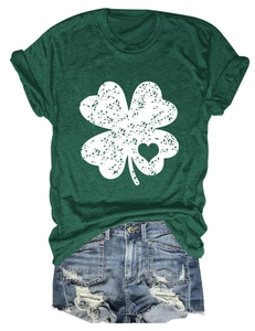 Flat lay of dark green T-shirt with clover heart print and distressed denim shorts