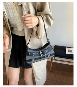 Detail of vintage punk saddle bag with metal eyelets and grey woven texture