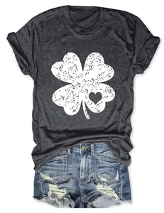 Flat lay of grey t-shirt with white distressed four-leaf clover and denim shorts