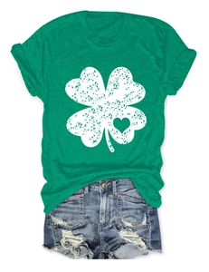 Flat lay of green clover T-shirt with heart cutout and distressed denim shorts outfit