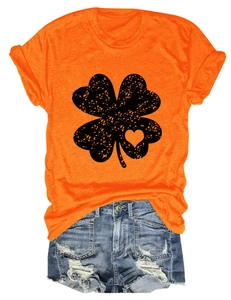 Detail of orange t-shirt with heart clover print paired with ripped denim shorts