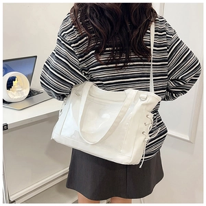 Détail du sac cabas blanc avec poche transparente en PVC et rubans sur le côté