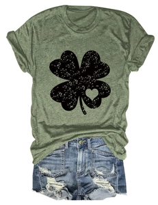 Detail of olive green t-shirt with four-leaf clover heart and distressed denim shorts