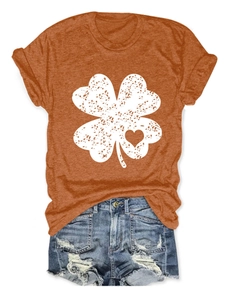 Close-up of rust orange T-shirt with clover heart print and distressed denim shorts