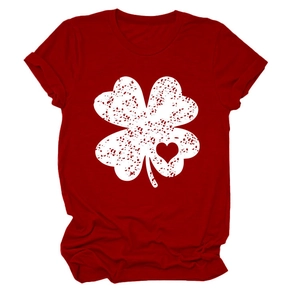 Close-up of vintage distressed four-leaf clover and heart print on red t-shirt