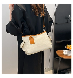 Casual cream canvas shoulder bag with brown leather trim shown on model for size and style