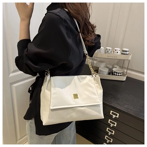 Detailed side view of a white PU leather shoulder bag with gold chain and metal buckle