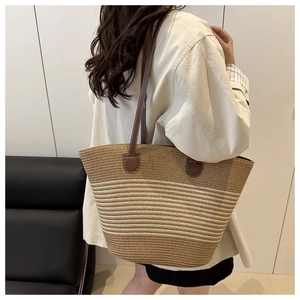 Close-up of woven tote bag featuring striped straw patterns and leather handle details