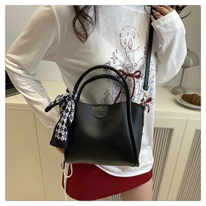 Dettaglio borsa a secchiello nera opaca con foulard a scacchi e testo JINGPIN