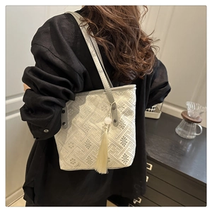 Dettaglio della borsa jacquard ricamata con elegante nappa lunga e tracolla in pelle