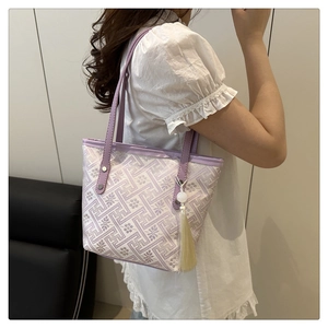 Close-up of lilac jacquard tote with geometric patterns and long silk tassel detail