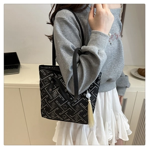 Dettaglio della borsa tote ricamata con nappa color crema e motivi floreali
