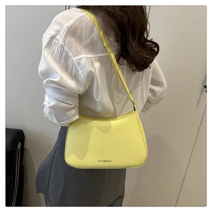 Detailansicht der gelben Leder-Schultertasche mit goldener Aufschrift und Textur