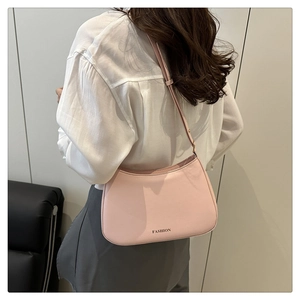 Detailansicht einer hellrosa Halbmond-Tasche mit minimalistischem FASHION-Schriftzug