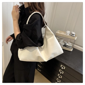 Close-up of white hobo bag with litchi texture and dual zippers on a model's shoulder
