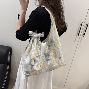 Floral canvas tote bag with lace bow accessory shown on model in a 45-degree side view