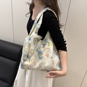 Detail view of floral embroidery and lace bow on ivory canvas shoulder tote bag
