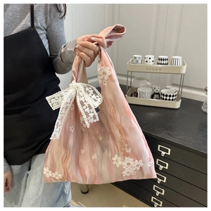 Detailed embroidery and lace bow on a pink marble pattern fabric handbag