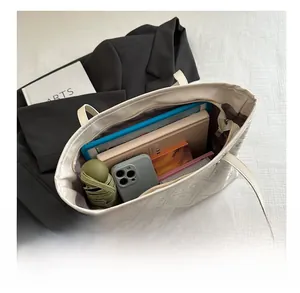 Detailed interior storage view of checkered tote bag holding umbrella, phone and tablet