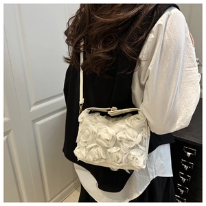 Detail of white evening bag with 3D fabric rose floral accents and slim shoulder strap