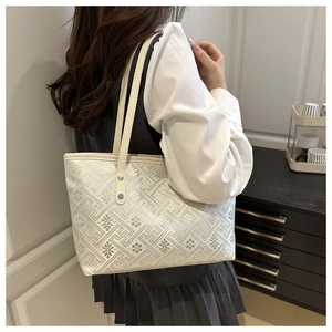 Detail of beige jacquard tote bag with traditional floral patterns on shoulder strap