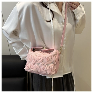 Detailed side view of pink crossbody bucket bag with 3D fabric rose floral accents