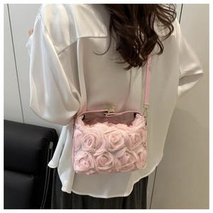 Détail de la pochette de soirée rose avec fleurs 3D en tulle et fermoir doré chic