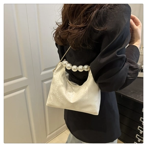Detail showing creamy white animal pattern texture and large pearl handle on a handbag