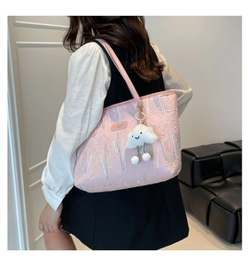 Close-up of pink tote bag featuring colorful wave embroidery and a plush cloud charm