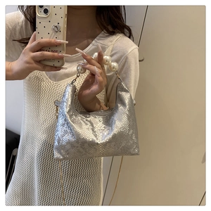 Detail of silver snake-print handbag featuring a luxury pearl bead handle and chain strap