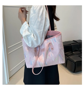 Detail of pink quilted tote bag with colorful wavy embroidery and metal brand logo plate