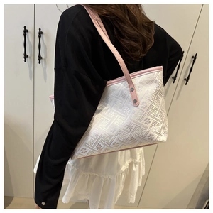 Detail of floral jacquard canvas tote with pink leather straps and rivet accents