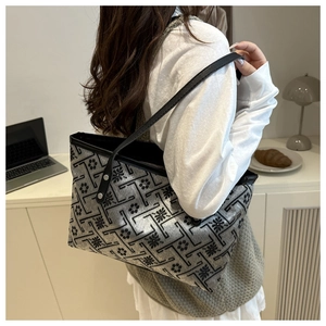 Detailed view of a large capacity tote bag with geometric floral patterns on a shoulder strap