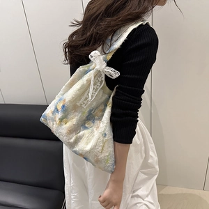 Floral embroidery canvas tote bag with lace bow accessory shown in shoulder carry style
