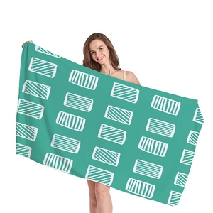 Minimalist beach towel with teal geometric rectangle patterns held by a female model