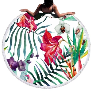 Round beach towel with tropical floral patterns, palm leaves and white fringe tassels