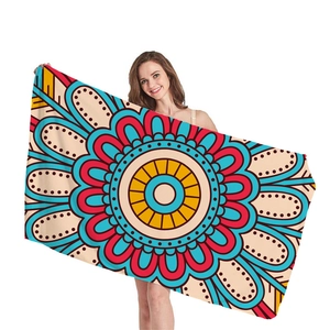 Vibrant mandala geometric beach towel with red and blue patterns on white background