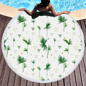 Thick round tropical palm leaf beach towel with white tassels by a poolside setting